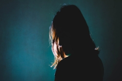 Woman in silhouette, looking sorrowful